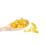 Vitamin E and wooden ladel on white background
